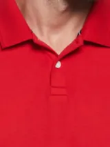 Polo roja de piqué de algodón orgánico, corte recto, cuello con solapa y logo bordado en el pecho.