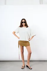 Minifalda de rayas verticales en tonos bordó y beige, confeccionada en tejido elástico con fruncidos laterales regulables mediante cordones.