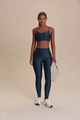 Calza deportiva de tiro alto con diseño de alta compresión y textura acanalada con leve brillo. Cuenta con un bolsillo trasero en la cintura y tecnología de ajuste adaptable.