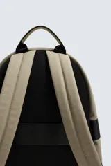 Mochila negra lisa con acabado engomado, compartimento principal con cierre de cremallera, bolsillo interior con cierre, bolsillo frontal con cierre, parte posterior acolchada con banda de sujeción para equipaje, asa de mano y dos asas de hombro ajustables y acolchadas.