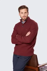 Buzo gris de tejido grueso con cuello alto y medio cierre con botones.