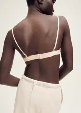 Sosten de diseño triangular con detalle de costura, perteneciente a la colección Selection. Presenta un diseño semitransparente con cierre de gancho en la parte posterior y breteles ajustables.