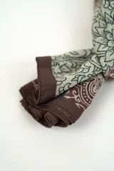 Pañuelo rectangular de diseño estampado con motivos florales y cachemira en tonos beige, bordó y negro, con bordes marrón oscuro.