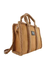 Cartera tipo tote de Las Oreiro, confeccionada en gamuza sintética color beige con detalles de corderito en los bordes y manijas. Incluye un parche frontal con el logo de la marca y correa ajustable extraíble.