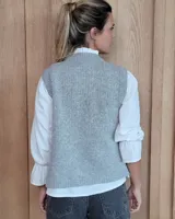 Chaleco de punto con diseño de trenzas, color gris oscuro, con cierre frontal de botones grandes y bolsillos laterales.