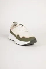 Zapatillas deportivas de gamuza color beige, con recortes en negro y marrón claro. Suela blanca de goma con base marrón.
