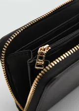 Billetera mediana de efecto cuero saffiano color negro, con cierre de cremallera perimetral, logo de la marca en relieve y múltiples ranuras para tarjetas.