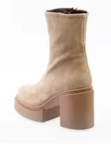 Botín de cuero negro con plataforma y taco cuadrado. Cierre lateral interno. Fabricado en España.