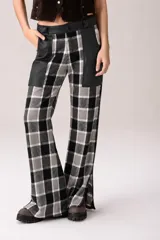 Pantalón de corte acampanado con diseño combinado. Presenta un estampado de cuadros tartán en tonos marrones, blancos y amarillos, con paneles laterales y bolsillos delanteros en cuero marrón oscuro.