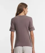 Blusa de viscosa color marrón topo, con cuello redondo y mangas cortas. Presenta aplicaciones de encaje tipo entremedios en las mangas y en la zona de los hombros.