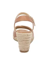 Sandalias con plataforma de yute color marrón claro, con dos tiras anchas cruzadas de cuero marrón y pulsera al tobillo con hebilla dorada.