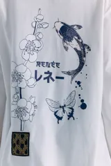 Remerón de manga larga y corte holgado, color blanco, con estampa serigráfica en la espalda que incluye motivos orientales como una rama de flores, un pez koi, una mariposa y texto en japonés. Presenta un parche decorativo en la parte inferior.