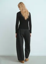 Jersey de canalé color negro, con cuello camisero, manga larga y diseño entallado. Cuenta con detalle de botón efecto joya.