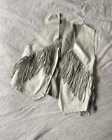 Chaleco negro de cuero vacuno con flecos largos en el frente y espalda.