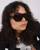 Lentes de sol Carey con forma geométrica, montura gruesa marrón con detalles en carey y lentes marrones.