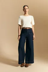 Remera de rib color beige, con cuello redondo y mangas cortas amplias con leve frunce en los hombros. Confeccionada en tejido elastizado de textura acanalada.