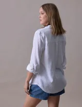 Camisa de lino marca Dash, color beige con rayas verticales blancas, cuello con solapa, cierre frontal de botones, bolsillo aplicado en el pecho y mangas largas con sistema para arremangar mediante presilla y botón.