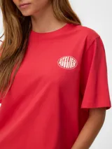 Remera de manga corta Vero Moda modelo Alina Caty, color rojo, con cuello redondo, calce regular y estampado circular en el pecho con la palabra "Atelier". Confeccionada en jersey de algodón orgánico.