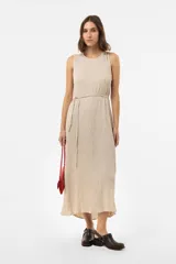 Vestido midi sin mangas de color beige, con escote redondo, silueta relajada y textura arrugada. Incluye un lazo fino para ajustar en la cintura.