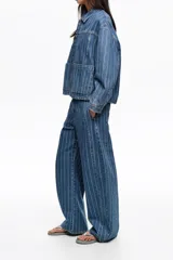 Pantalón de jean estilo balloon, color azul con diseño de rayas verticales finas en tono claro. Cuenta con tiro medio y corte amplio en las piernas.