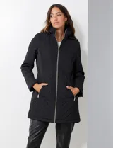 Campera capitoneada de corte largo con diseño de costuras multidireccionales, combinando un patrón de rombos en el cuerpo con capitoneado lineal en laterales y hombros. Cuenta con cierre frontal completo, cuello alto reforzado, capucha desmontable ajustable con cordones y bolsillos laterales con cierre invisible.