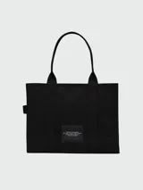 Bolso tote de gran tamaño en color negro, confeccionado en lona resistente. Presenta el logo distintivo de la marca estampado en blanco en el frente y doble asa superior para llevar al hombro.
