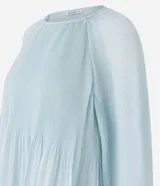 Blusa de crepé en color verde agua claro, con cuello redondo y mangas largas voluminosas. Presenta un diseño con textura plisada tanto en las mangas como en el cuerpo de la prenda, con puños ajustados.