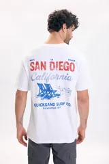 Remera blanca de manga corta con gran estampado gráfico en la espalda con la leyenda "San Diego California" y un dibujo de reposeras de playa.