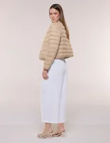 Campera puffer corta de diseño reversible y liviano, marca Michael Kors. Cuenta con acabado resistente al agua, diseño acolchado con matelaseado horizontal, cuello redondo a la base sin solapa ni capucha, cierre frontal completo con botones de presión metálicos, bolsillos laterales funcionales y ribetes a tono. Largo a la cintura y empacable en su propia bolsa de guardado.