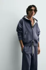 Sudadera de algodón con efecto lavado, color azul oscuro/gris pizarra, de corte 'boxy fit' y cierre frontal de cremallera. El interior de la capucha está forrado en tejido waffle de color gris claro. Posee bolsillos frontales de plastrón.