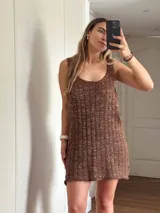 Vestido corto de tejido de punto, color marrón con hilos dorados (lurex) que le dan un brillo sutil. Diseño de tirantes anchos y escote redondo.