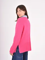 Buzo de tejido de punto color negro, con cuello redondo, mangas largas y puños anchos acanalados. Presenta un diseño con ruedo asimétrico y aberturas laterales.