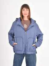 Campera acolchada de color azul, con diseño de costuras en rombos, cierre frontal, capucha y bolsillos delanteros amplios.