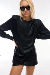 Minivestido negro con brillos, mangas largas y hombreras.
