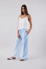 Pantalón celeste a rayas verticales blancas, de corte palazzo y cintura alta con elástico.