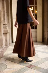 Falda larga de corte acampanado con tablas anchas, confeccionada en algodón color marrón.
