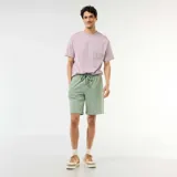 Bermuda verde de felpa ligera, de corte recto y holgado, con cintura elástica ajustable mediante cordón.