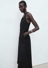 Vestido midi sin mangas con cuello en pico, cierre frontal con botones y cinturón ajustable a la cintura. Presenta un diseño evasé con bolsillos laterales y forro interior.