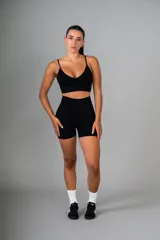 Top deportivo color beige con breteles finos cruzados en la espalda.