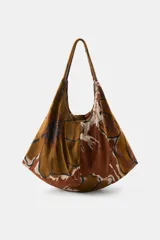 Maxi bolsa de hombro confeccionada en algodón, con diseño estampado en tonos marrones y beige, de gran capacidad y asas superiores.
