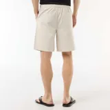 Bermuda chino color gris claro, de corte recto, con cintura elástica ajustable mediante cordón y bolsillos laterales.