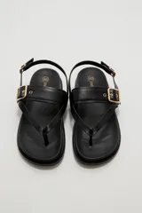 Sandalias negras de eco cuero estilo chunky, con diseño de tiras cruzadas y hebilla metálica dorada en la parte superior. Cuenta con tira ajustable en el talón.