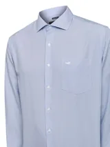 Camisa de manga larga RKF con diseño de rayas verticales finas en azul y blanco. Presenta cuello italiano, cierre frontal con botones, puños abotonados y un bolsillo en el pecho con el logo de la marca bordado.