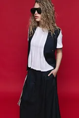 Remera de algodón color blanco con diseño de tablas verticales en el frente que aportan movimiento y estructura.