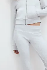 Pantalón de felpa gris melange, tiro alto con cintura elástica ancha y corte flare en las piernas.