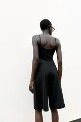 Bermuda de tiro medio color negro, con cintura elástica y detalle de pliegues delanteros.