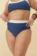 Bombacha de bikini tiro alto color negro con detalle de banda superior en color blanco.