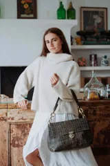 Cartera de hombro con textura efecto cocodrilo en color marrón oscuro. Presenta un diseño rectangular con solapa frontal, cierre metálico a presión y una correa de cadena gruesa en tono dorado.