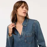 Blusa de jean de corte recto, con cuello polo, escote en V y bolsillo frontal en el pecho. Presenta mangas largas y un diseño de calce holgado.