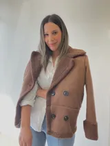 Chaqueta negra con forro tipo corderito, doble botonadura y cuello solapa.